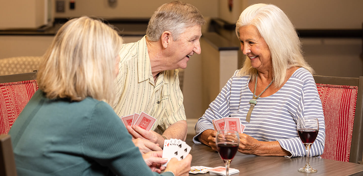senior living community residents playing cards at a table