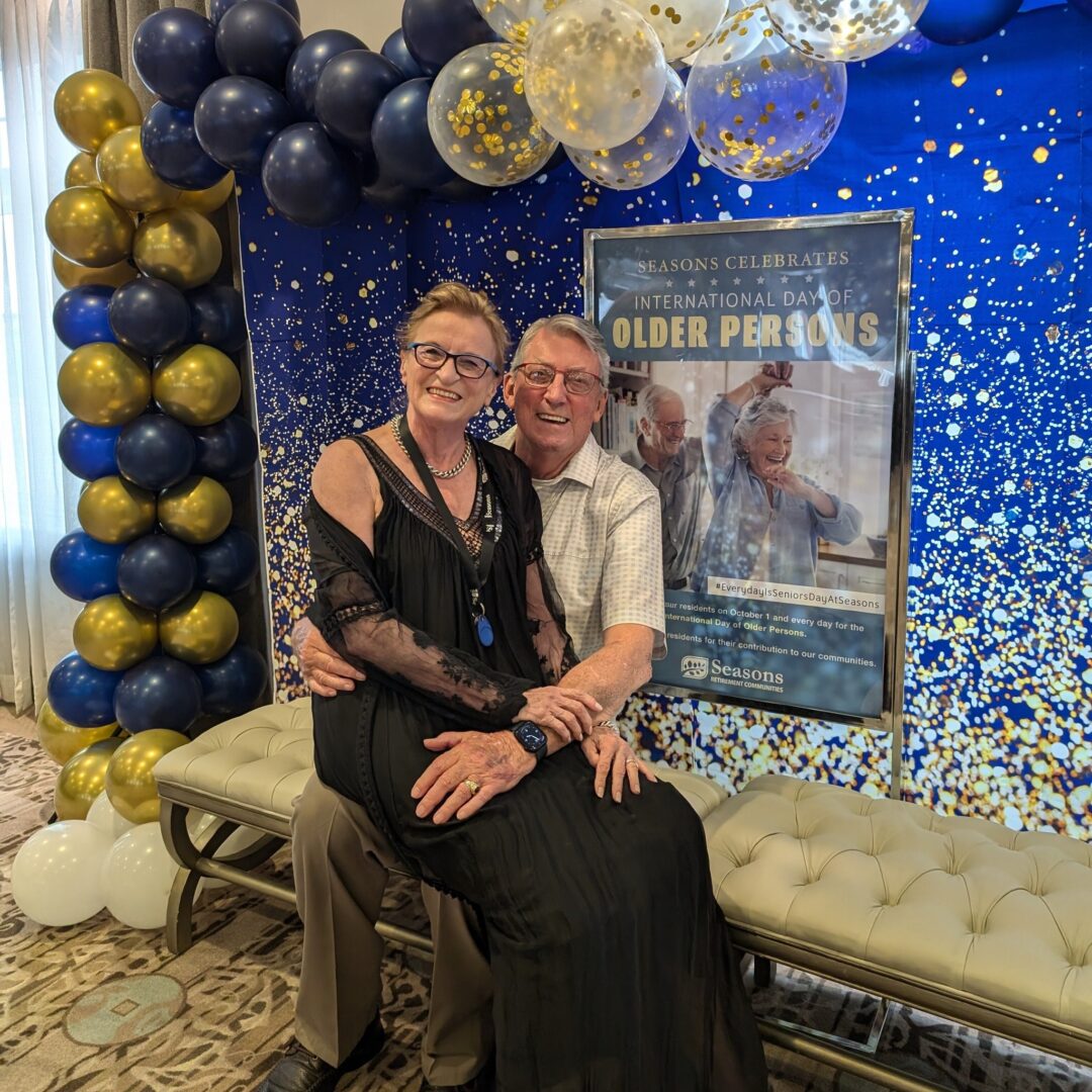 Resident Couple sitting in front of international day of older persons display