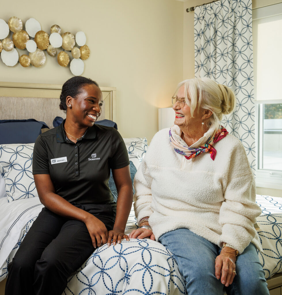 seasons team member sitting and speaking with elderly woman