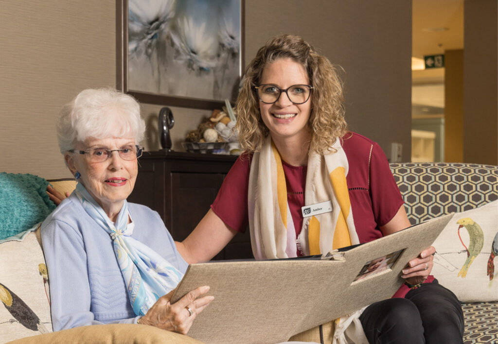 Seasons team member viewing photo album with senior resident.